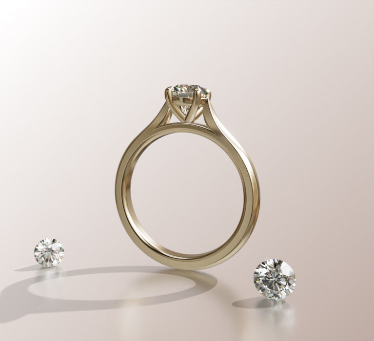 Złoty pierścionek zaręczynowy z diamentem oraz dwa diamenty luzem na jasnym tle